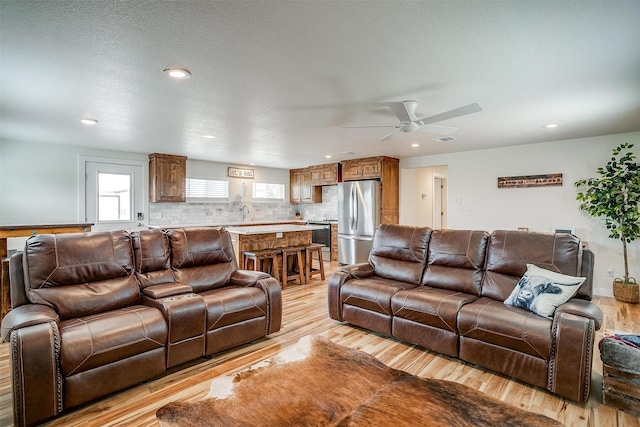 living area with light wood-style flooring, recessed lighting, visible vents, and ceiling fan