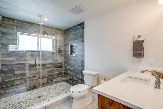 full bathroom with toilet, vanity, a shower stall, tile patterned flooring, and visible vents