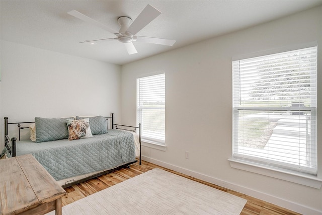 bedroom with baseboards, ceiling fan, and wood finished floors