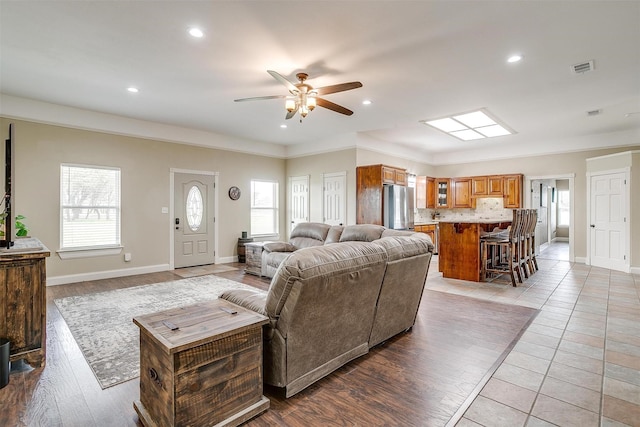 living room featuring baseboards, visible vents, recessed lighting, and a ceiling fan