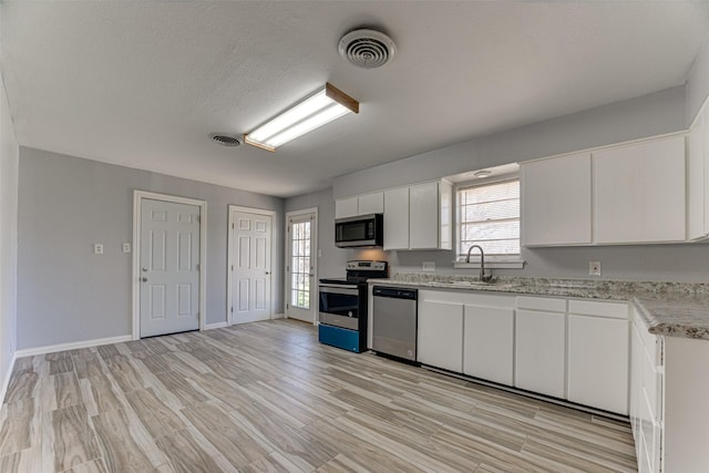 1805 Austin Dr, Kaufman, TX 75142 - kitchen with light wood-type flooring, a sink, visible vents, and stainless steel appliances
