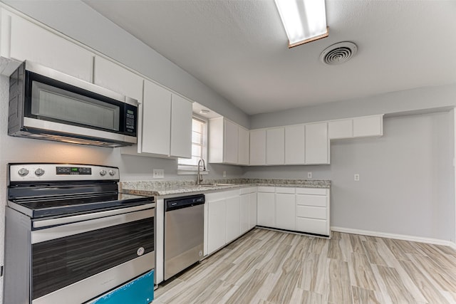 1805 Austin Dr, Kaufman, TX 75142 - kitchen featuring visible vents, white cabinets, a sink, appliances with stainless steel finishes, and light wood-type flooring