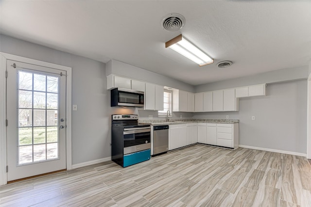 1805 Austin Dr, Kaufman, TX 75142 - kitchen featuring light wood-style flooring, light countertops, visible vents, and stainless steel appliances