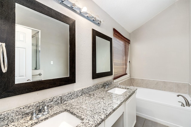bathroom with a sink, tile patterned floors, a garden tub, and double vanity
