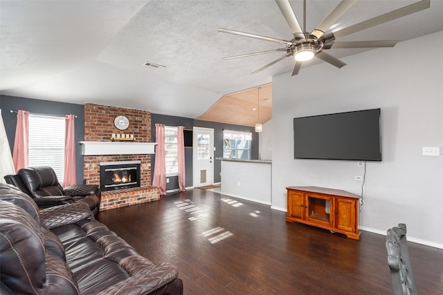 living area featuring visible vents, lofted ceiling, baseboards, hardwood / wood-style flooring, and a ceiling fan