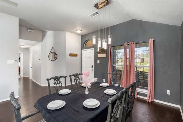 dining room with baseboards, vaulted ceiling, wood finished floors, and visible vents