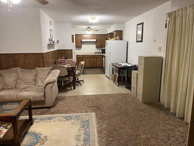1717 Oak Tree Dr, Denton, TX 76209 - living area featuring wainscoting, a ceiling fan, and a textured ceiling