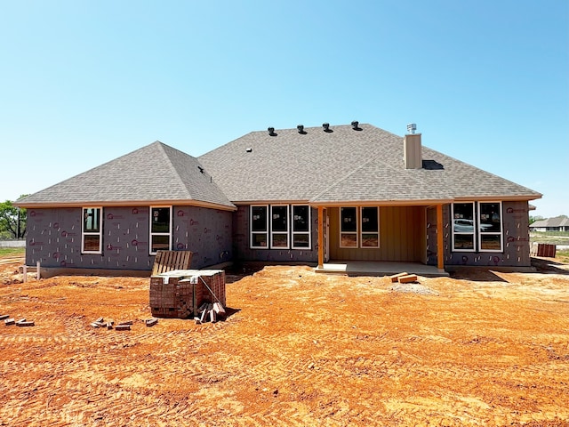 1005 Ronnie Ct, Springtown, TX 76082 - back of property featuring a shingled roof, a patio area, and board and batten siding