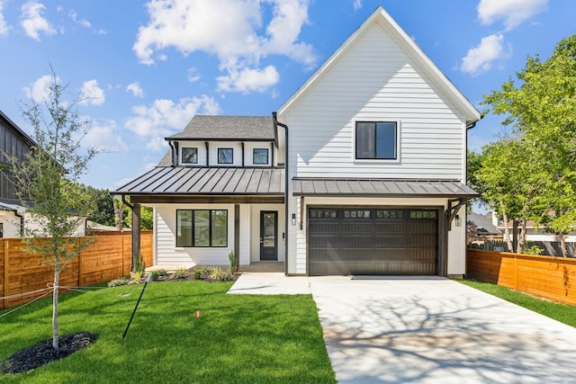 4513 Lakecrest Dr, The Colony, TX 75056 - view of front facade featuring a standing seam roof, concrete driveway, a garage, covered porch, and metal roof