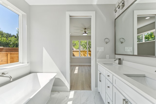 4513 Lakecrest Dr, The Colony, TX 75056 - full bath featuring a freestanding tub, baseboards, a ceiling fan, marble finish flooring, and double vanity
