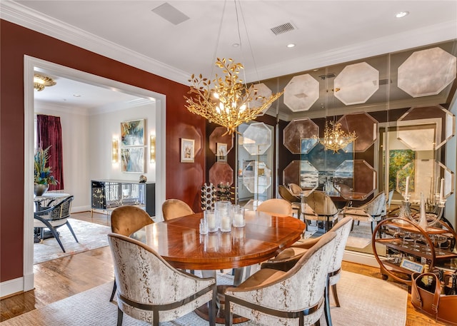 dining area featuring crown molding, an inviting chandelier, visible vents, wood finished floors, and baseboards