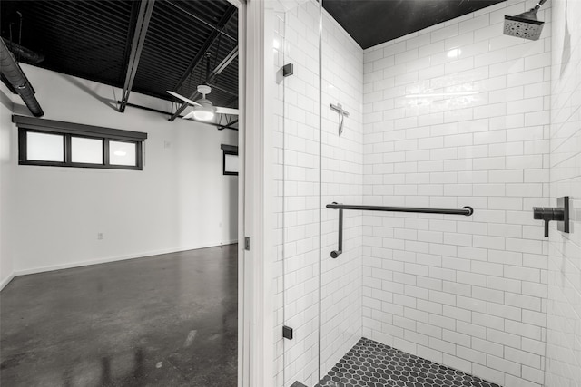 bathroom featuring baseboards, concrete flooring, and a shower stall