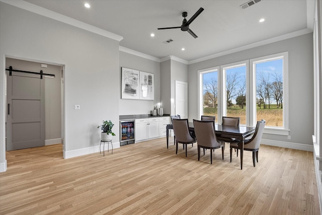909 Saint Anne Ct, Heath, TX 75032 - dining space with a barn door, wine cooler, crown molding, baseboards, and a ceiling fan