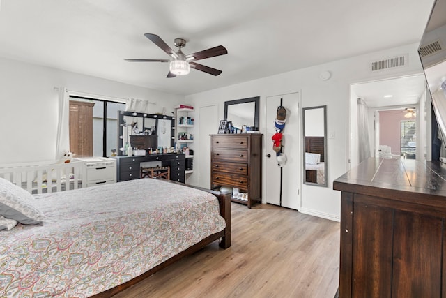 bedroom with visible vents, a ceiling fan, and light wood finished floors
