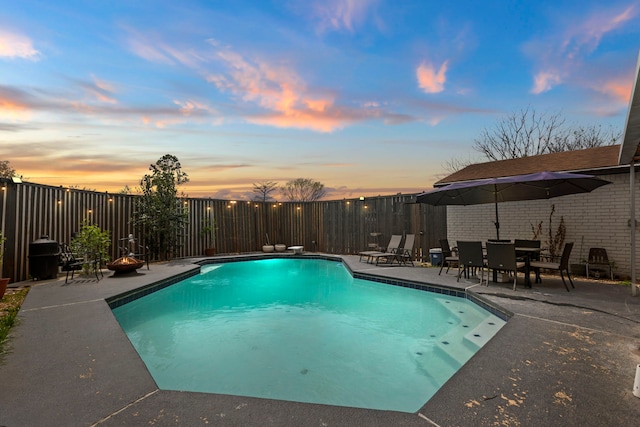 view of swimming pool with a diving board, a fenced in pool, fence, and a patio area