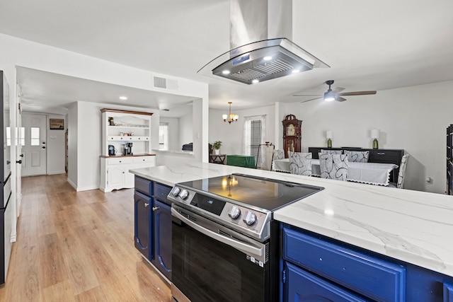 kitchen featuring visible vents, island exhaust hood, blue cabinetry, stainless steel range with electric cooktop, and ceiling fan with notable chandelier