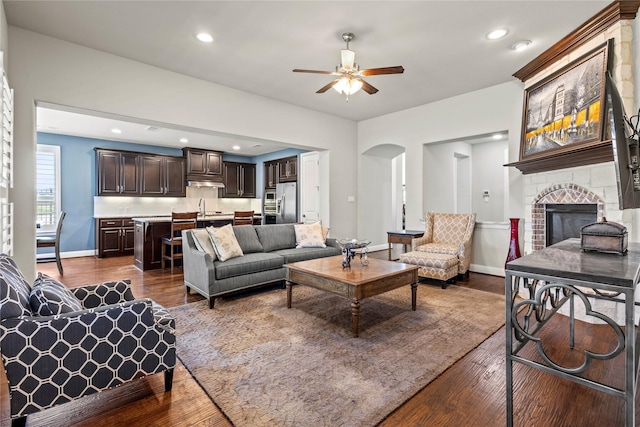 1630 Old Oak Ct, Prosper, TX 75078 - living room with ceiling fan, dark wood finished floors, arched walkways, a brick fireplace, and recessed lighting