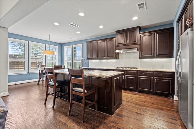 1630 Old Oak Ct, Prosper, TX 75078 - kitchen with stainless steel appliances, a sink, dark wood finished floors, a center island with sink, and backsplash