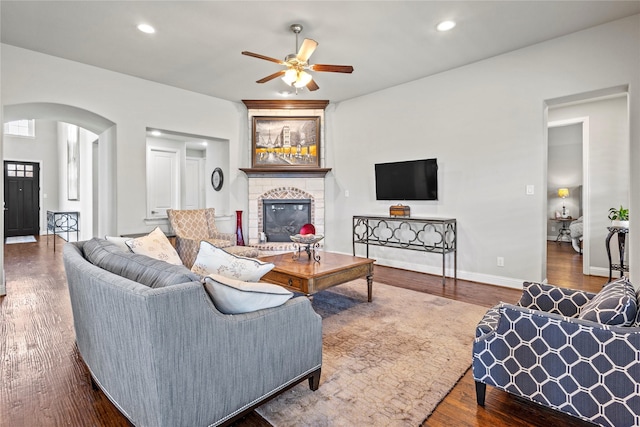 1630 Old Oak Ct, Prosper, TX 75078 - living room featuring arched walkways, ceiling fan, a fireplace, wood finished floors, and recessed lighting