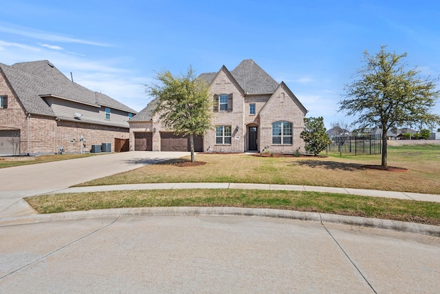 1630 Old Oak Ct, Prosper, TX 75078 - french country inspired facade featuring concrete driveway, brick siding, a garage, and central AC unit