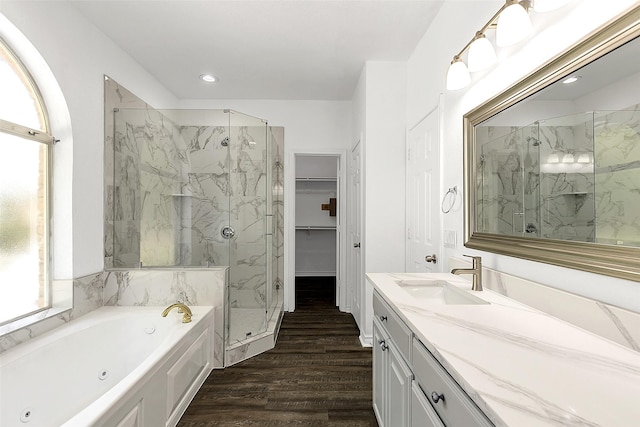 2858 Waters Edge, Quinlan, TX 75474 - bathroom with wood finished floors, a marble finish shower, a walk in closet, vanity, and a whirlpool tub