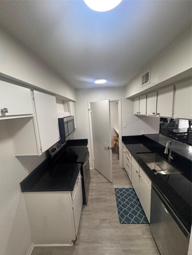 kitchen featuring white cabinetry, a sink, stainless steel appliances, and visible vents