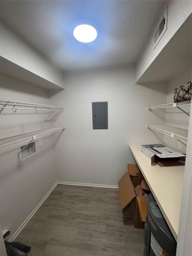 walk in closet with visible vents, electric panel, and dark wood finished floors