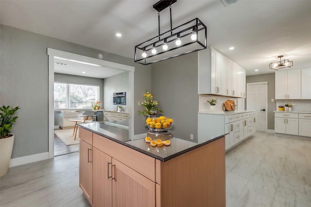 kitchen with marble finish floor, white cabinetry, decorative backsplash, and recessed lighting