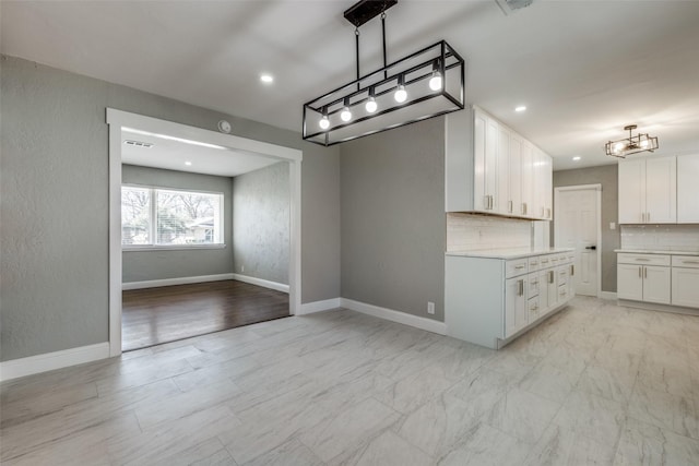 unfurnished dining area with a chandelier, marble finish floor, baseboards, visible vents, and recessed lighting