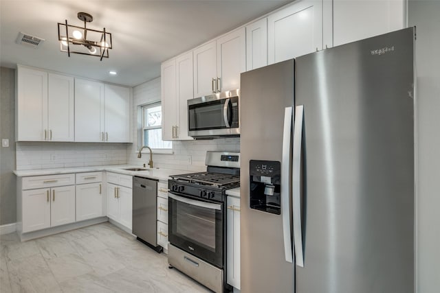 kitchen featuring a sink, stainless steel appliances, marble finish floor, visible vents, and white cabinets