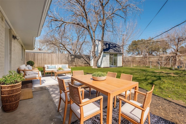 view of patio / terrace featuring an outbuilding, a fenced backyard, an outdoor hangout area, and outdoor dining space