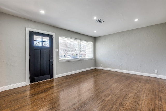 entryway featuring wood finished floors, baseboards, and visible vents