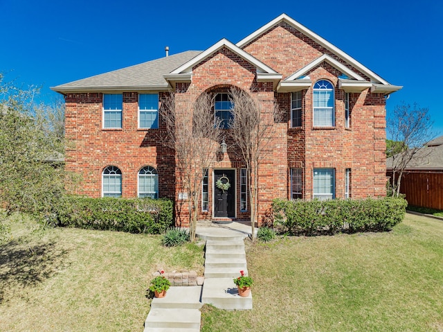 view of front of house with brick siding and a front yard