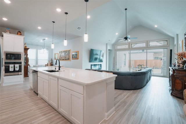 kitchen with open floor plan, a sink, visible vents, and stainless steel appliances