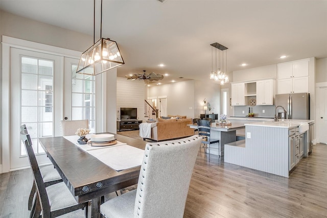 dining room with light wood-style flooring, an inviting chandelier, and recessed lighting