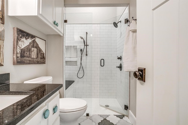full bath with vanity, a shower stall, and toilet