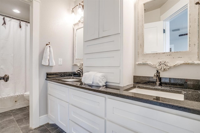 full bathroom with curtained shower, a sink, double vanity, and toilet