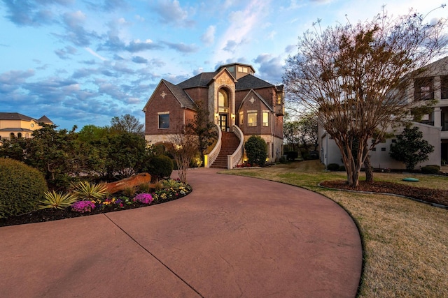 181 Monarch Dr, Denison, TX 75020 - view of front of property with curved driveway, stairway, stone siding, a front yard, and brick siding