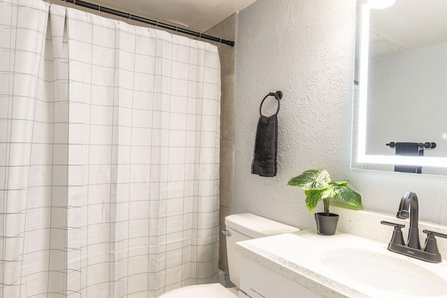 full bath with a textured wall, toilet, vanity, and a shower with curtain