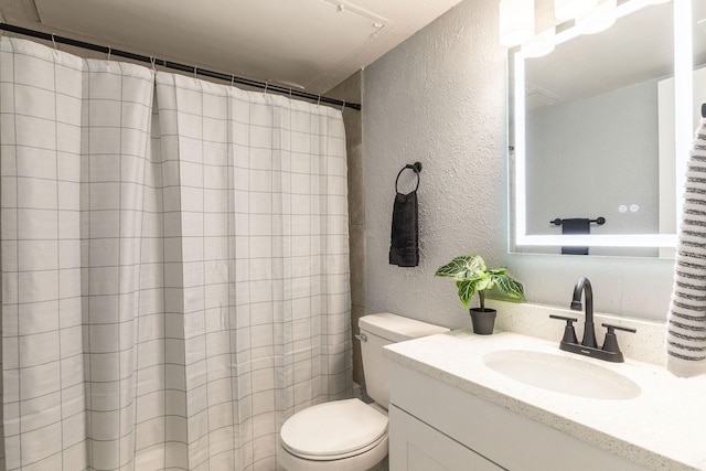 full bath with a textured wall, toilet, vanity, and a shower with curtain