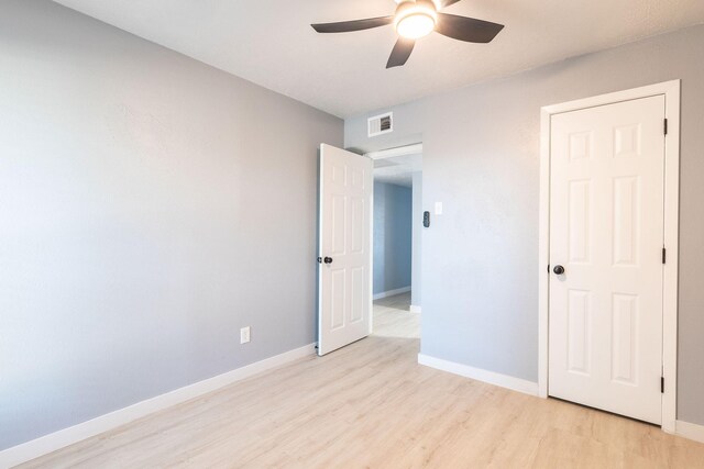 unfurnished bedroom with light wood-style floors, baseboards, and a ceiling fan