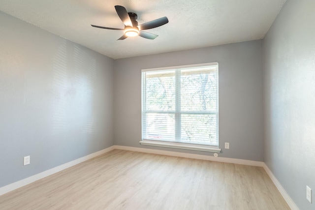 empty room with light wood finished floors, ceiling fan, and baseboards
