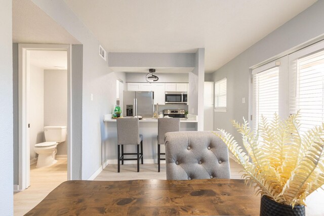 dining space with light wood finished floors and baseboards