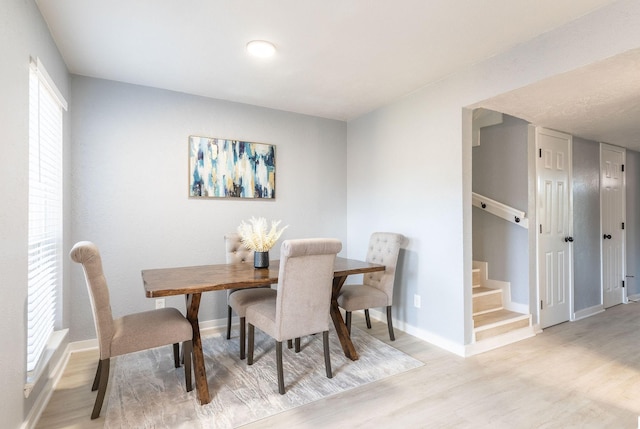 dining area with wood finished floors, stairs, and baseboards