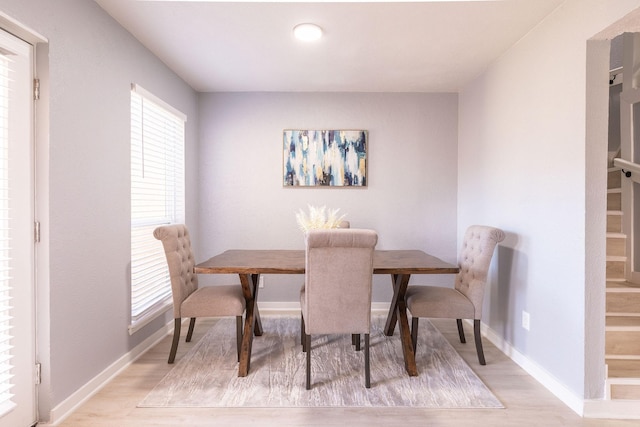 dining area featuring light wood finished floors and baseboards