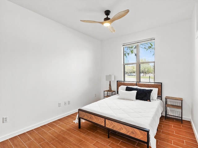 bedroom with a ceiling fan, baseboards, and wood tiled floor
