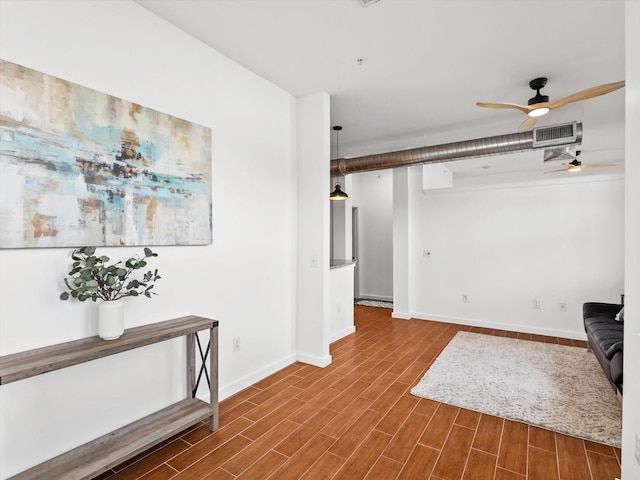 unfurnished room with baseboards, visible vents, wood finish floors, and a ceiling fan