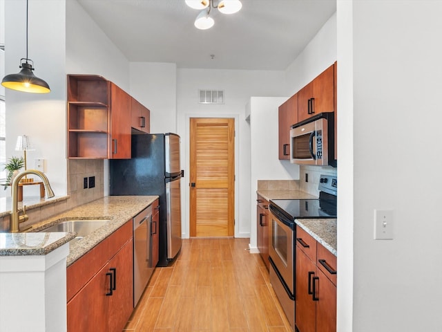 kitchen with a sink, backsplash, open shelves, appliances with stainless steel finishes, and visible vents