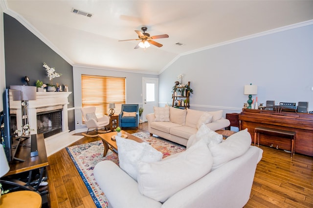 living room with crown molding, a ceiling fan, vaulted ceiling, visible vents, and wood finished floors