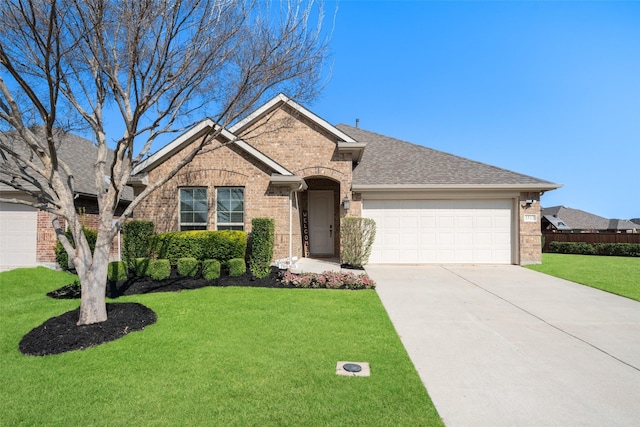 single story home featuring driveway, roof with shingles, brick siding, a front lawn, and a garage